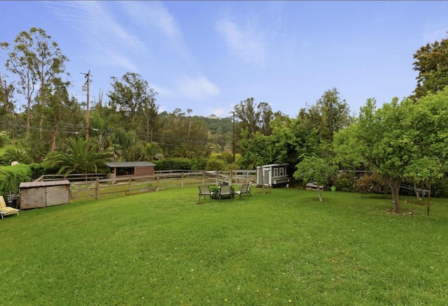 view of yard featuring an outbuilding and fence