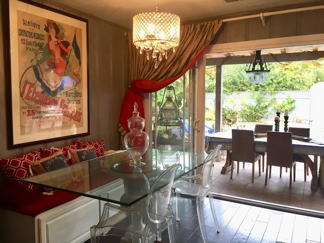 dining area with wood finished floors and an inviting chandelier