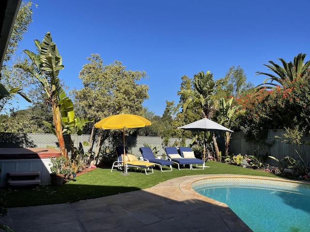 view of swimming pool with a fenced in pool, a patio area, a fenced backyard, and a lawn