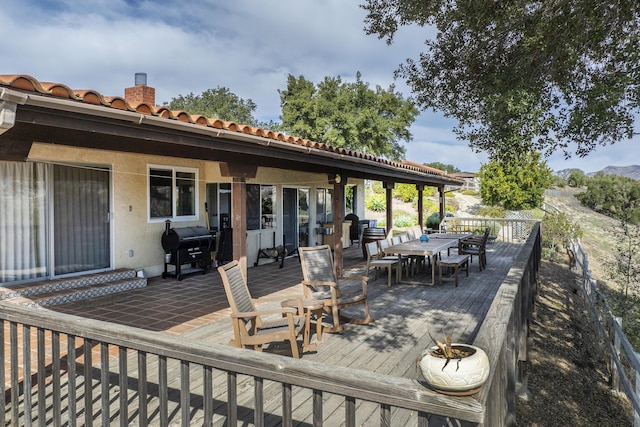 wooden deck featuring outdoor dining area and a grill