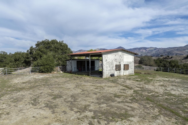 view of outbuilding featuring a rural view, an exterior structure, an outdoor structure, and a mountain view