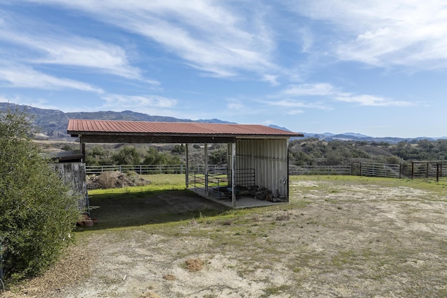 exterior space featuring an exterior structure, a rural view, and a mountain view