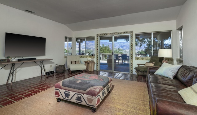 living room with tile patterned flooring, visible vents, and vaulted ceiling