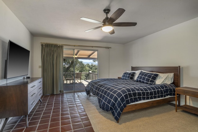 bedroom featuring ceiling fan, dark tile patterned floors, and access to exterior