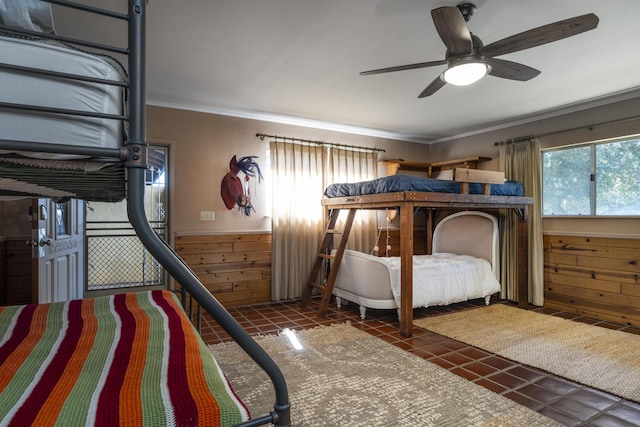 tiled bedroom with a wainscoted wall, ceiling fan, ornamental molding, and wood walls