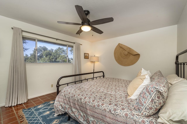 tiled bedroom with baseboards and a ceiling fan