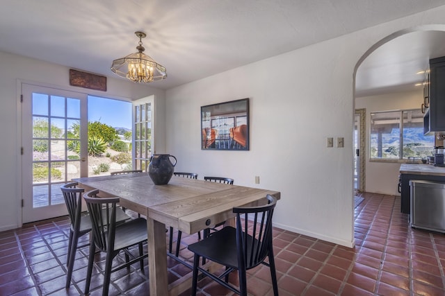 3776 Live Oak Rd, Santa Ynez, CA 93460 - dining space with arched walkways, dark tile patterned floors, a chandelier, and a healthy amount of sunlight