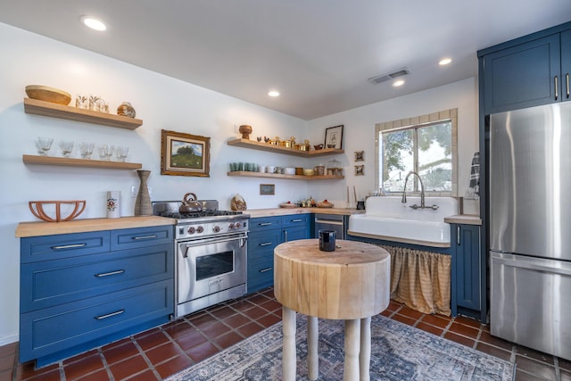 3776 Live Oak Rd, Santa Ynez, CA 93460 - kitchen with blue cabinets, stainless steel appliances, butcher block counters, and a sink