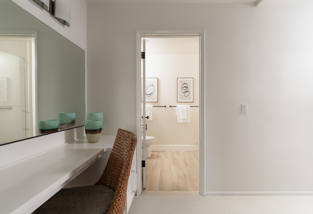 bathroom with toilet, baseboards, wood finished floors, and vanity