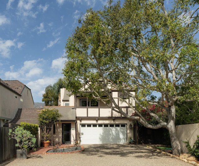 view of front of property featuring driveway, stucco siding, an attached garage, and a tiled roof