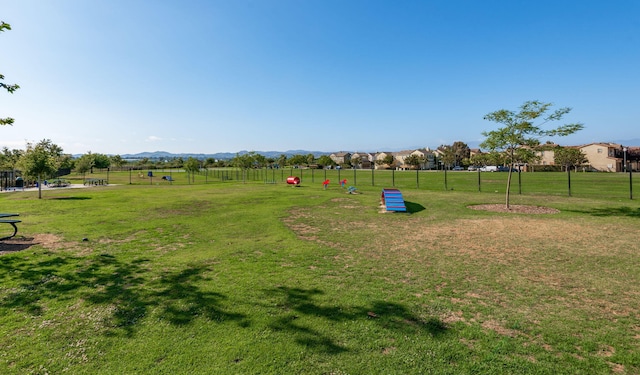 view of property's community with fence and a yard