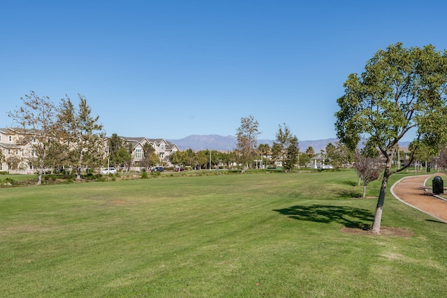 surrounding community featuring a mountain view and a lawn