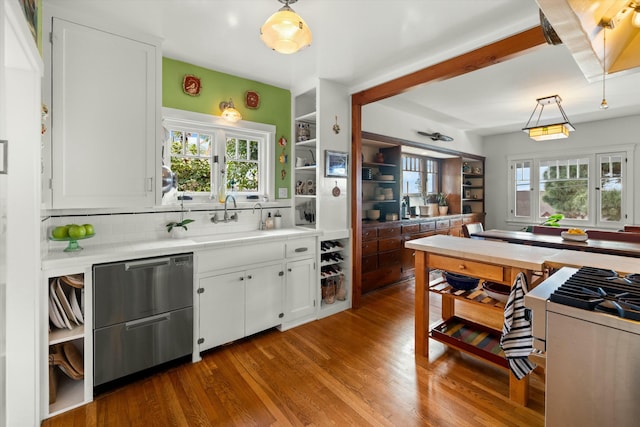 kitchen featuring a wealth of natural light, a sink, tile counters, and white cabinets