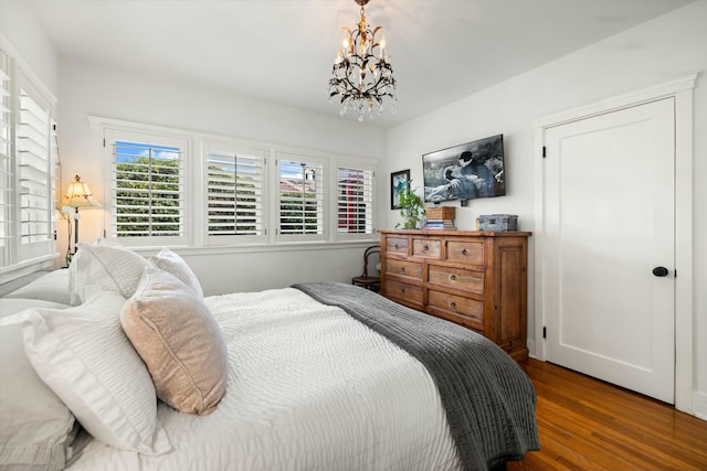 bedroom with a chandelier and wood finished floors