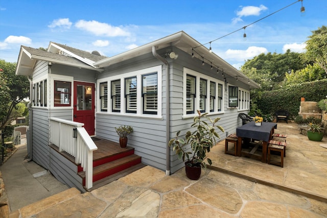 view of front of house with outdoor dining space and a patio area