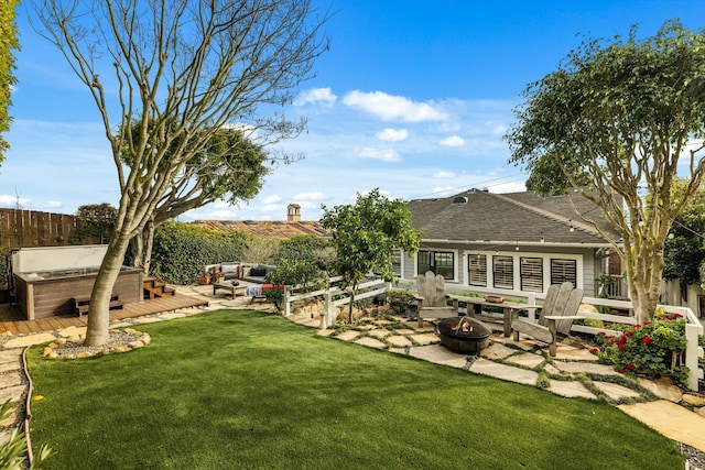 view of yard with a patio, fence, a wooden deck, an outdoor living space with a fire pit, and a hot tub