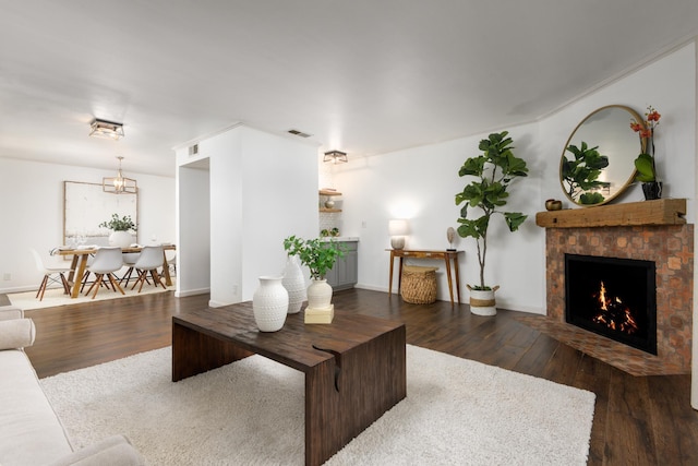 living area featuring a fireplace, wood finished floors, visible vents, and baseboards