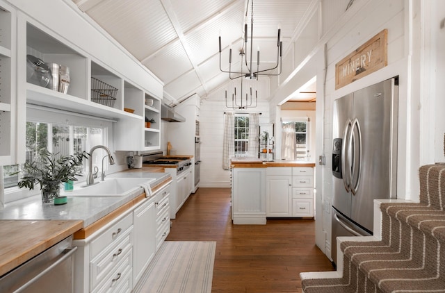 kitchen with open shelves, stainless steel appliances, a chandelier, a sink, and butcher block countertops