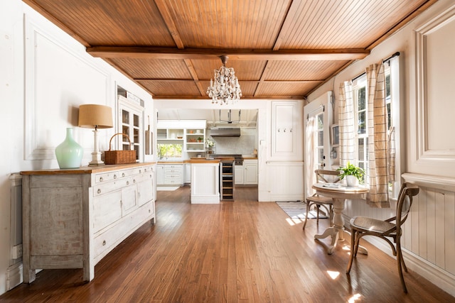 interior space with open shelves, wood finished floors, beamed ceiling, and wood counters