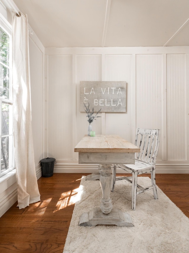 dining area featuring a decorative wall and wood finished floors