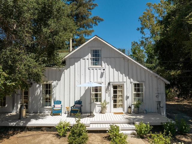 rear view of property with a deck and board and batten siding