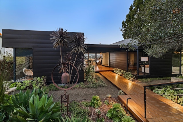 back of house featuring a deck and log veneer siding