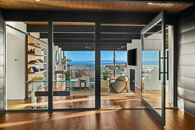 doorway to outside with beamed ceiling, floor to ceiling windows, wood ceiling, and hardwood / wood-style flooring