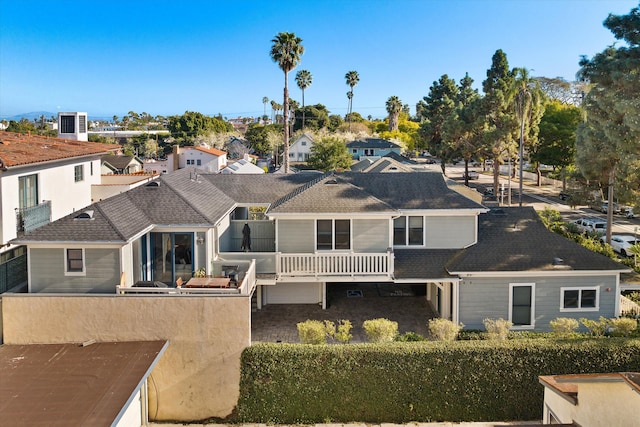 view of front of home with a residential view, fence, and a shingled roof