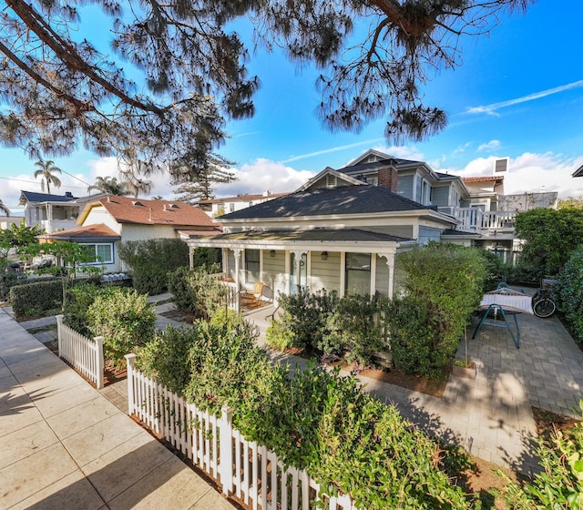 view of front of home featuring a patio and fence