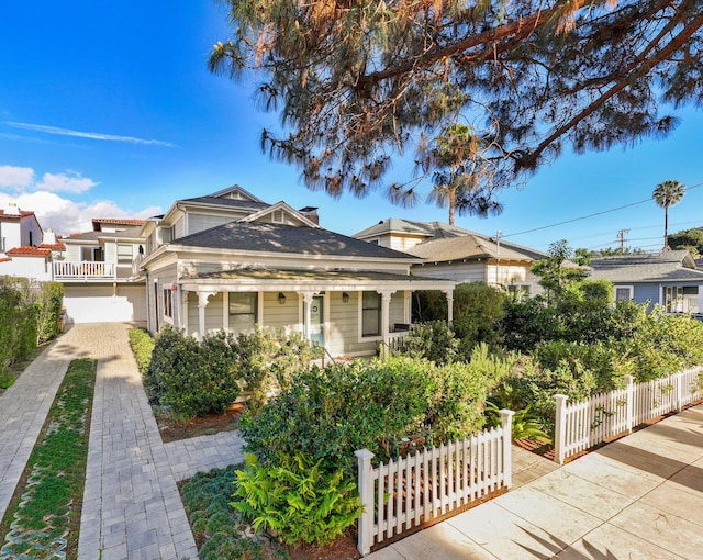 view of front facade with decorative driveway and a fenced front yard