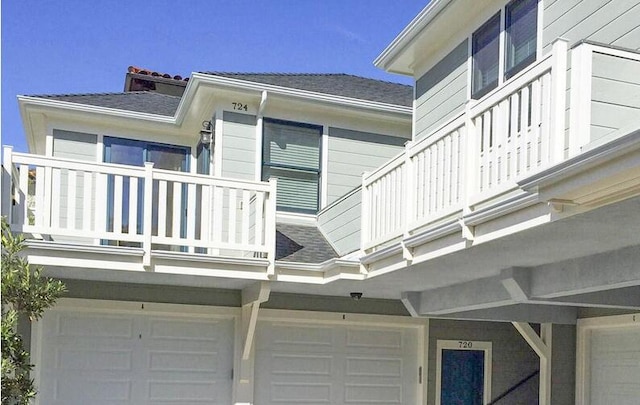 view of property exterior featuring a garage and a shingled roof