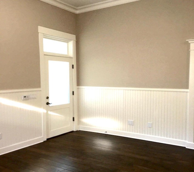 interior space featuring crown molding, wood finished floors, and a wainscoted wall