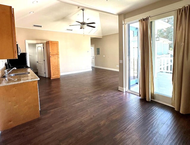 kitchen with dark wood finished floors, visible vents, lofted ceiling, and a sink