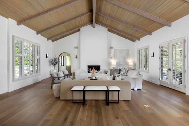living room with high vaulted ceiling, baseboards, hardwood / wood-style flooring, and a fireplace