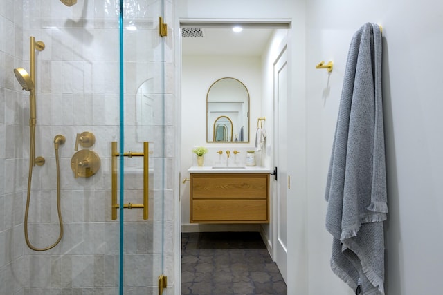 bathroom featuring tiled shower and vanity