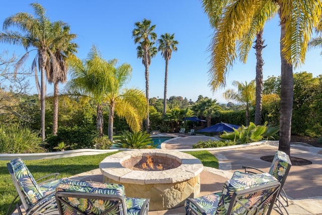 view of community with a patio and an outdoor fire pit