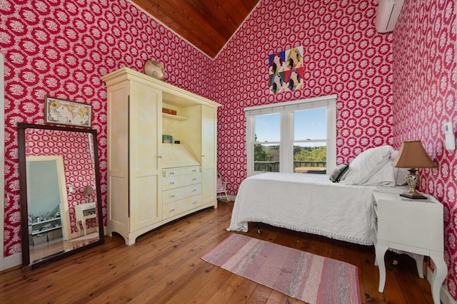 bedroom featuring a wall mounted air conditioner, wallpapered walls, and hardwood / wood-style flooring