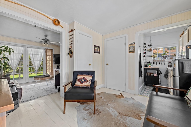 foyer entrance with heating unit, wood walls, light wood finished floors, and ceiling fan