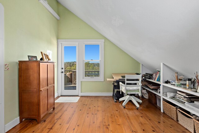 office area featuring baseboards, light wood-style floors, and vaulted ceiling