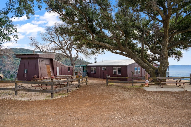 view of yard featuring an outbuilding, fence, and a mountain view