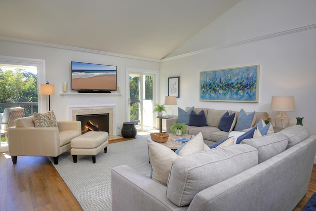 living room featuring crown molding, a fireplace with flush hearth, wood finished floors, and high vaulted ceiling