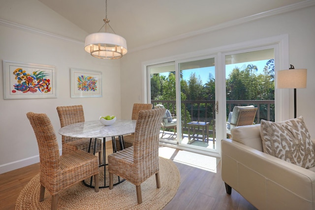 dining space with vaulted ceiling, wood finished floors, and baseboards