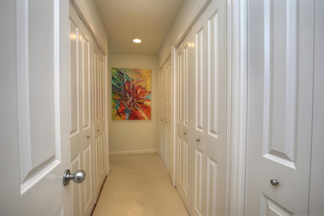 corridor with recessed lighting, light colored carpet, and baseboards