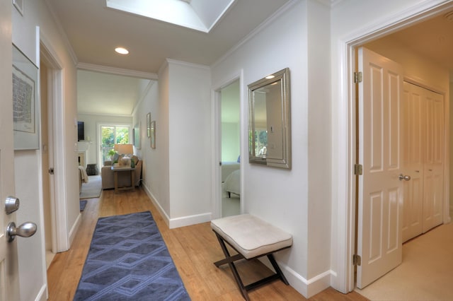 corridor with recessed lighting, crown molding, light wood-type flooring, and baseboards