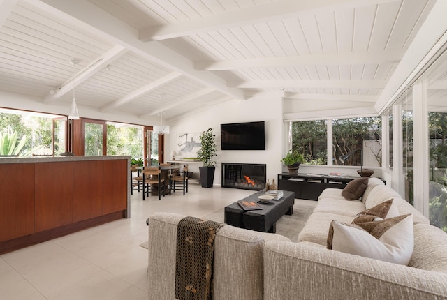 sunroom / solarium with a glass covered fireplace and lofted ceiling with beams