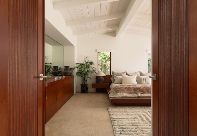 carpeted bedroom featuring lofted ceiling with beams