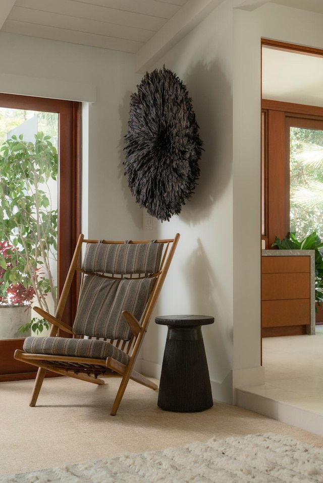 living area with beam ceiling and carpet