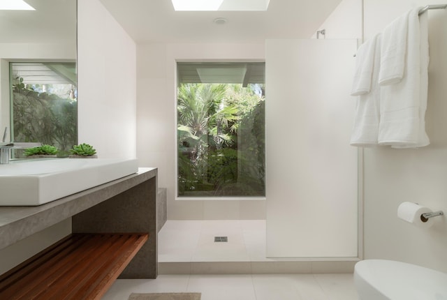 bathroom featuring vanity, tile patterned floors, a skylight, and toilet