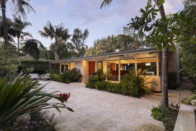 back of property featuring concrete block siding, a patio area, and driveway