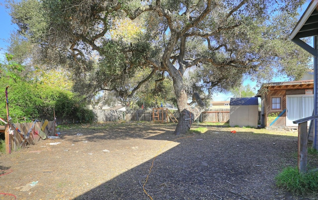 view of yard featuring a fenced backyard, an outdoor structure, and a storage shed